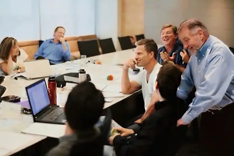 Business owners sharing a laugh around a peer group meeting table